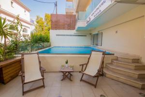 a patio with two chairs and a swimming pool at Grand Boutique in Vasiliki