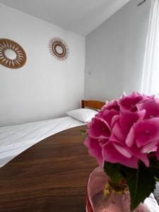 a vase with a pink flower in a room at Domek pod Jabłonią in Barzowice