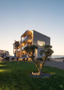 a building with a tree in front of it at Pnoe Boutique suites in Nikiti