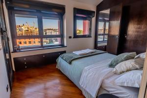 a bedroom with a bed and two windows at Acquarium dream apartment kate in Genoa