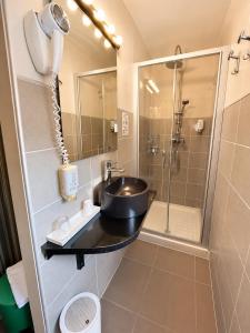 a bathroom with a sink and a shower at Hôtel Duc De Padoue in Corte +29 photos
