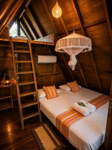 a bedroom with a bunk bed and a ladder at Wilpattu Green Cabin in Achchamulai