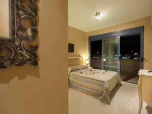 1 dormitorio con cama y ventana con vistas en Livingtarifa Apartamento La Isla, en Tarifa