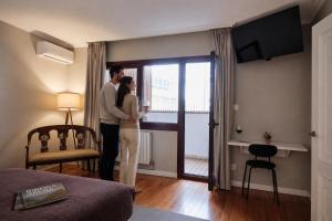 a man and a woman standing in a hotel room at Hotel Mogay in Chantada