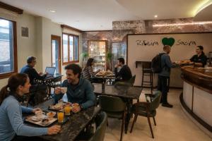 a group of people sitting at tables in a restaurant at Hotel Mogay in Chantada