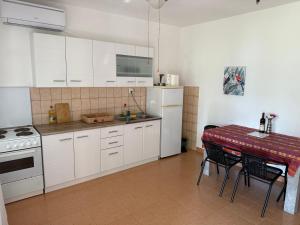 a kitchen with white cabinets and a table with chairs at Vista View Apartments in Risan