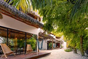 a resort with two chairs and a table and trees at Ca Nikte Cabañas in El Cuyo