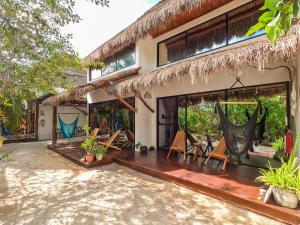 a house with a deck and chairs outside of it at Ca Nikte Cabañas in El Cuyo
