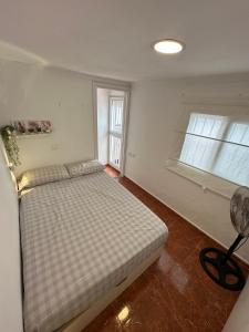 a bedroom with a bed and a window and a fan at Apartamento La Línea 3 in La Línea de la Concepción +4 photos