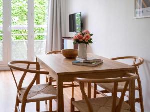 a dining room table with a vase of flowers on it at Paris Bercy with car park by Melvane in Charenton-le-Pont