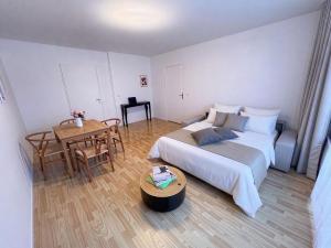 a small bedroom with a bed and a table at Paris Bercy with car park by Melvane in Charenton-le-Pont