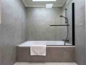 a bathroom with a bath tub and a shower at Paris Bercy with car park by Melvane in Charenton-le-Pont