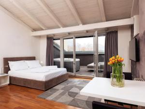 a bedroom with a bed and a table with flowers at SOUL OF TRENTO Exclusive Jacuzzi Loft in Trento