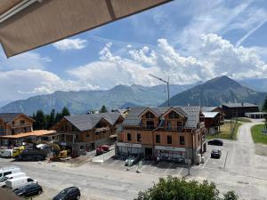 a view of a town with mountains in the background at Appartement pied ESF in La Toussuire