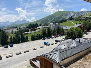 a parking lot in a town with mountains in the background at Appartement pied ESF in La Toussuire