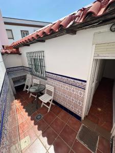 a patio with two chairs and a table on a house at Apartamento La Línea 3 in La Línea de la Concepción
