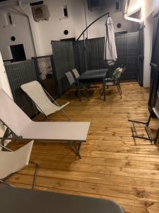 a room with chairs and a table on a wooden floor at Marathi élégance T2 neuf avec SPA privatif in Biscarrosse