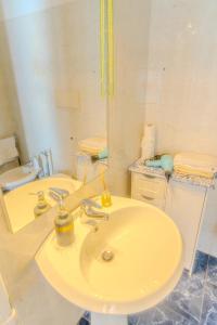 a white bathroom with a sink and a mirror at APPARTAMENTO SUL MARE KATE in Genoa +37 photos