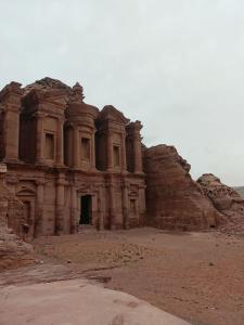 an old building in the desert with a rock at Petra Planet in Wadi Musa