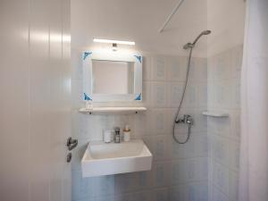 a white bathroom with a sink and a shower at Akteon Hotel in Logaras +87 photos