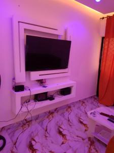 a living room with a television on a white wall at Residence Angevita in Edéa