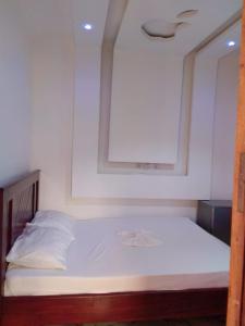 a bedroom with a white bed with a mirror at Residence Angevita in Edéa