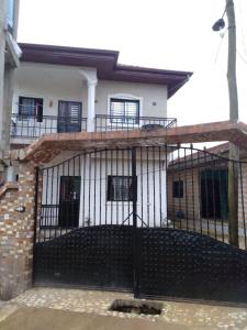 a house with a black gate in front of it at Residence Angevita in Edéa