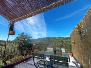 a patio with a table and chairs on a deck at Quinta Pedra do Rio - Penedo in Salvador do Monte