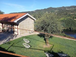 a balcony with two chairs on the grass at Quinta Pedra do Rio - Penedo in Salvador do Monte