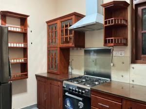 a kitchen with wooden cabinets and a stove top oven at Villa Sadalla in Hikkaduwa