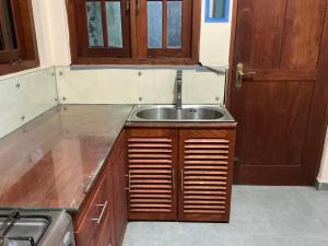a kitchen with a sink and wooden cabinets at Villa Sadalla in Hikkaduwa +18 photos