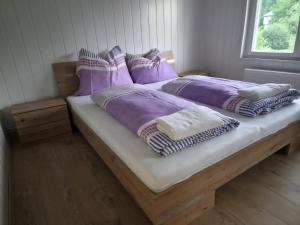 a bedroom with two beds with purple comforters and a window at Apartments Rainbow in Pörtschach am Wörthersee