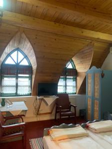 a room with two beds and a desk and two windows at Góbé Csárda in Oradea