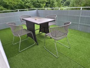 a table and chairs on a patio with grass at Apartments Rainbow in Pörtschach am Wörthersee