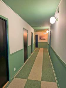 an empty hallway with green and white walls and doors at Hotel Amadeus Halmstad in Halmstad +26 photos