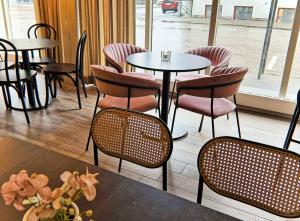 a group of tables and chairs in a restaurant at Hotel Amadeus Halmstad in Halmstad