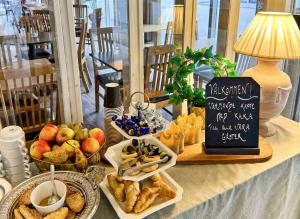 a table topped with plates of food and a sign at Hotel Amadeus Halmstad in Halmstad