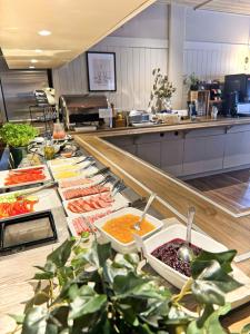 a buffet line with many different types of food at Hotel Amadeus Halmstad in Halmstad