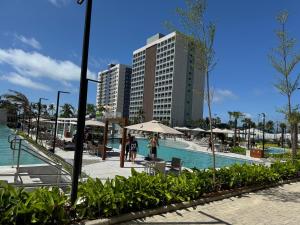 a resort with a swimming pool and a tall building at Salinas Beach Resort in Salinópolis