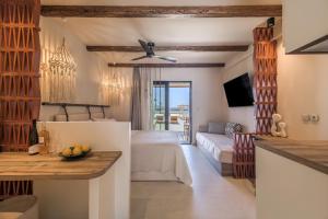 a bedroom with a bed and a living room at Zefyria Luxury Suites in Zefiría