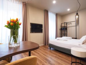 a bedroom with a bed and a table with a vase of flowers at SOUL OF TRENTO San Martino in Trento