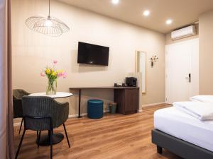 a room with a bed and a table with flowers on it at SOUL OF TRENTO San Martino in Trento