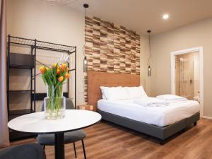a bedroom with a bed and a table with a vase of flowers at SOUL OF TRENTO San Martino in Trento +21 photos