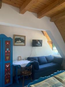 a living room with a blue couch and a table at Góbé Csárda in Oradea