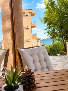 a white chair sitting on a balcony with a pineapple at Adriatic Monte Apartments in Tušupi