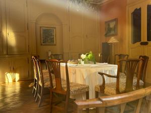 a dining room with a white table and chairs at L Epernon in Alençon