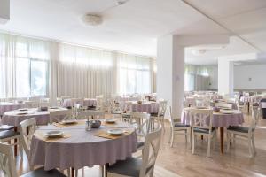 a dining room with tables and chairs with purple table cloth at Hotel La Carica in Pastrengo +12 photos