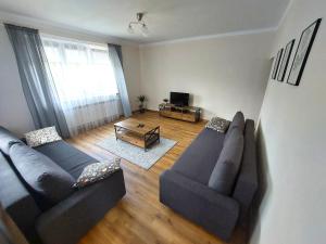 a living room with two couches and a table at Dom u Tosi pod Zatorem in Spytkowice