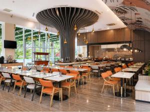 a dining room with tables and chairs in a restaurant at Mercure Serpong Alam Sutera in Serpong