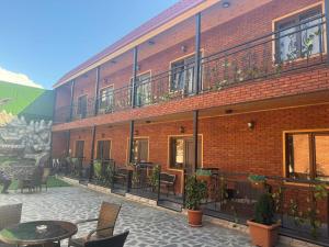 a brick building with a patio with tables and chairs at Lux hotel in Tbilisi City